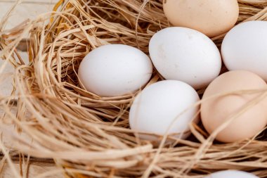 ahşap bir arka plan üzerinde saman çiğ yumurta