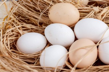 ahşap bir arka plan üzerinde saman çiğ yumurta