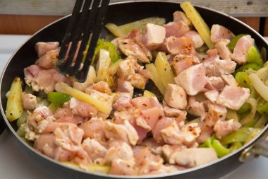 tavuk elektrikli bir soba üzerinde bir tavada kızartılır. ev aşçı