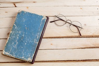 ahşap arka plan üzerinde vintage kitaplar ve vintage optik gözlük. üstten görünüm