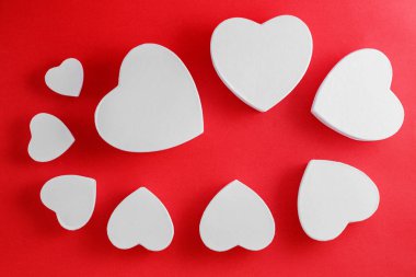 white heart-shaped cardboard boxes on red background