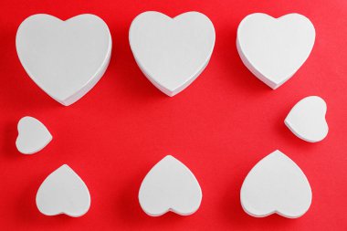 white heart-shaped cardboard boxes on red background