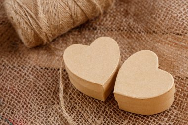 ahşap bir arka plan üzerinde tuval üzerinde bir kalp şeklinde karton kutular