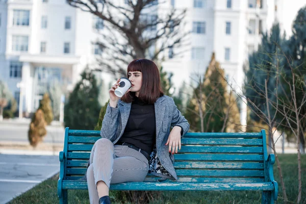 Bir Fincan Kahve Ile Bir Bankta Oturan Güzel Genç Kadın — Stok fotoğraf