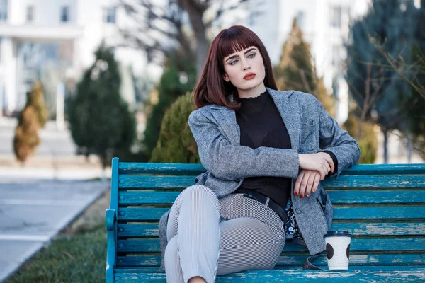 Hermosa Joven Sentada Banco Con Una Taza Café —  Fotos de Stock