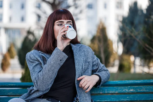 Mooie Jonge Vrouw Zittend Een Bankje Met Een Kopje Koffie — Stockfoto