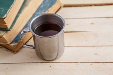 eski kitaplar ve tahta bir masada bir fincan çay. üst görünüm.