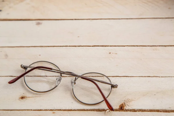 vintage books and vintage optical glasses on wooden background. the view from the top