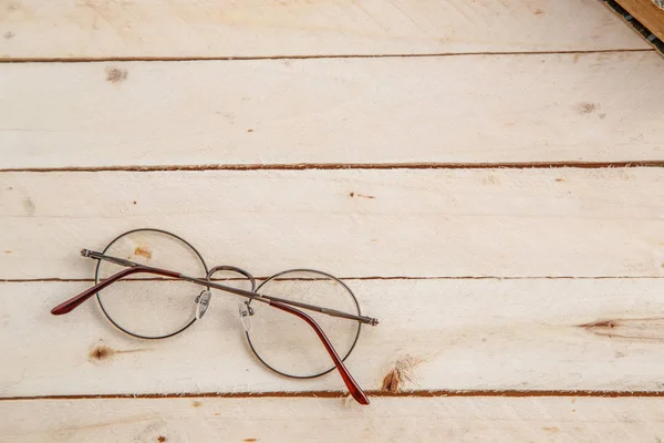 vintage books and vintage optical glasses on wooden background. the view from the top