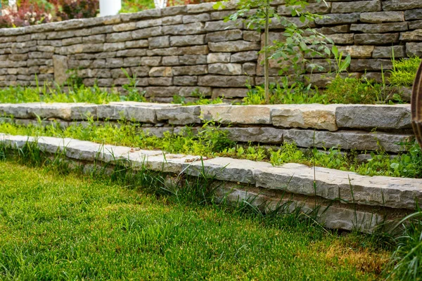 green lawn and stone path with stone walls