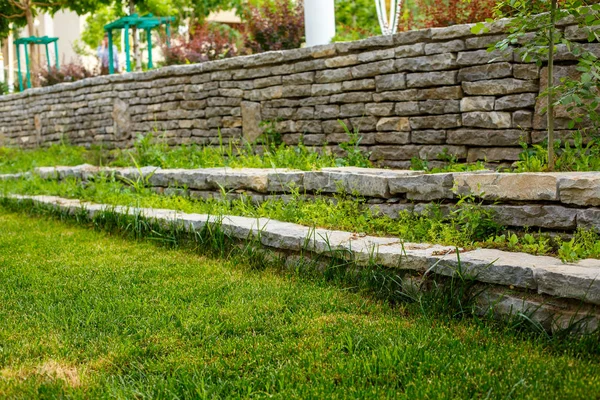 Green lawn and stone path with stone walls Stock Image