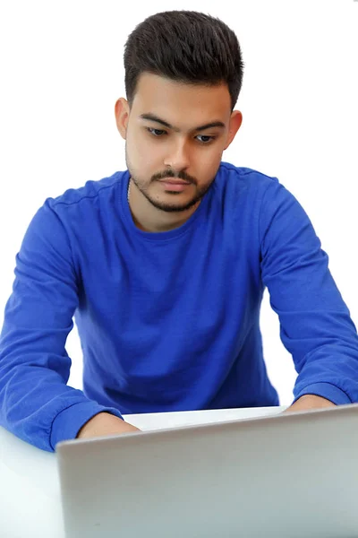 Ein junger Mann sitzt an einem Laptop auf der Suche nach Arbeit und macht Geschäfte — Stockfoto