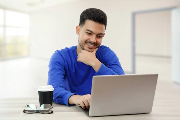 Ein junger Mann sitzt am Laptop auf der Suche nach Arbeit im Internet. — Stockfoto