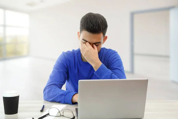 Un joven que trabaja en un portátil. Está enojado y cansado. sobre blanco — Foto de Stock