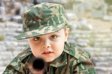 askeri giysiler içinde küçük Kafkas çocuk ve oyuncak silah ile