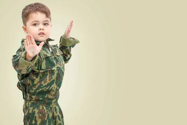 Petit garçon caucasien en vêtements militaires isolé sur la lumière backg — Photo