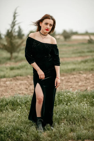 Νέα όμορφη γυναίκα σε μαύρο φόρεμα ποζάρουν για έναν φωτογράφο o — Φωτογραφία Αρχείου