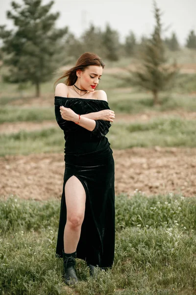 Jovem mulher bonita em vestido preto posando para um fotógrafo o — Fotografia de Stock