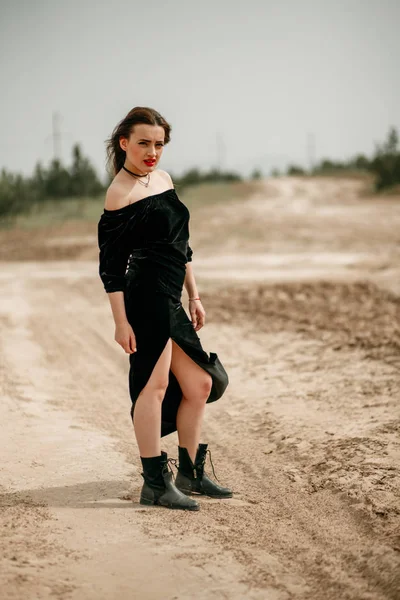 Joven hermosa mujer en vestido negro posando para un fotógrafo o — Foto de Stock