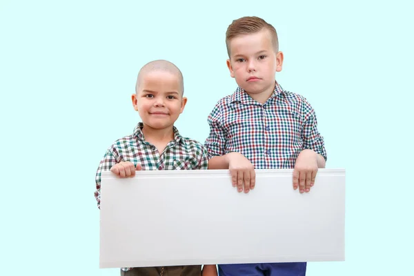 Retrato de dos niños sosteniendo un cartel blanco sobre un fondo aislado — Foto de Stock