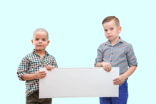 Portrait de deux garçons tenant une pancarte blanche sur fond isolé — Photo