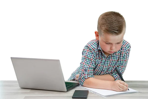 Kaukasiska skolåldern pojke i en pläd skjorta sitter vid bordet en — Stockfoto