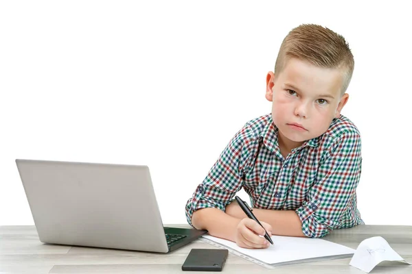 Kaukasiska skolåldern pojke i en pläd skjorta sitter vid bordet en — Stockfoto