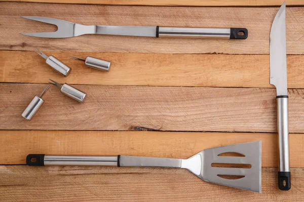 Set métallique pour découper la viande et griller sur fond bois — Photo