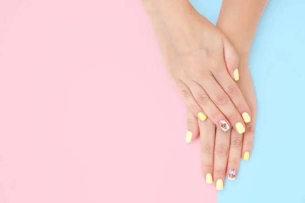 Women's hands with a beautiful manicure with drawings of cakes a — Stock Photo, Image