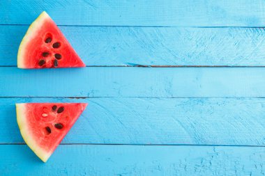 mavi ahşap vintage arka plan üzerinde kırmızı kızıl karpuz parçaları.
