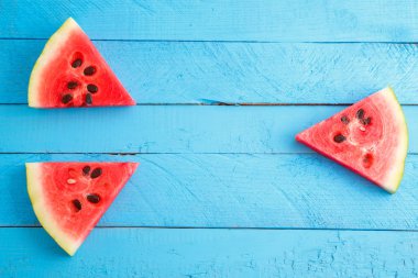 mavi ahşap vintage arka plan üzerinde kırmızı kızıl karpuz parçaları.