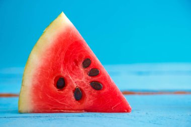 mavi ahşap arka planda bir karpuz parçası