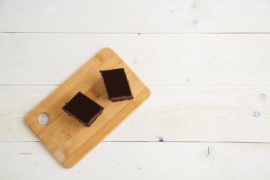 ile beyaz ahşap arka plan üzerinde bir bambu tepsi üzerinde brownie kek 