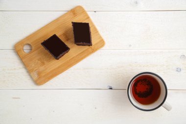 beyaz ahşap üzerinde çay cuo ile bir bambu tepside brownie kek 