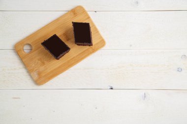 ile beyaz ahşap arka plan üzerinde bir bambu tepsi üzerinde brownie kek 
