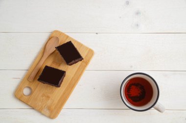 beyaz ahşap üzerinde çay cuo ile bir bambu tepside brownie kek 