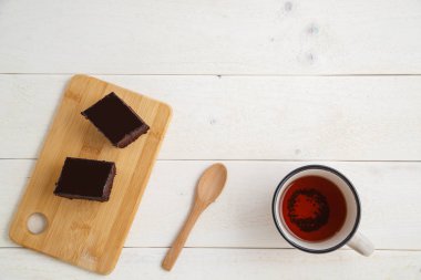 beyaz ahşap üzerinde çay cuo ile bir bambu tepside brownie kek 