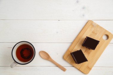beyaz ahşap üzerinde çay cuo ile bir bambu tepside brownie kek 