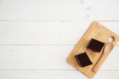 ile beyaz ahşap arka plan üzerinde bir bambu tepsi üzerinde brownie kek 