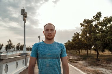 mavi bir t-shirt ve siyah şort kafkas adam portresi kim