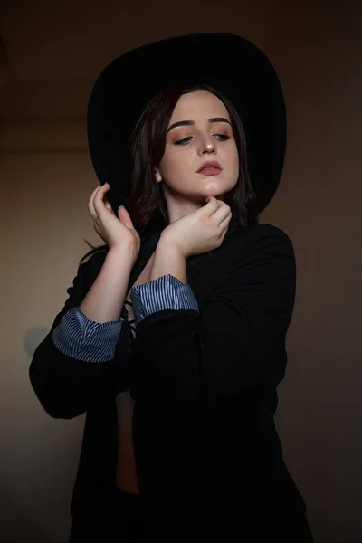 Jeune belle femme en veste noire avec chapeau noir et u noir — Photo