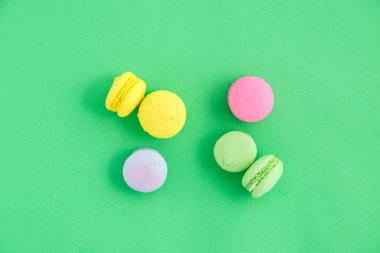 yeşil arka plan üzerinde renkli macarons veya macaroons çerezleri. Sayfanın Üstü 