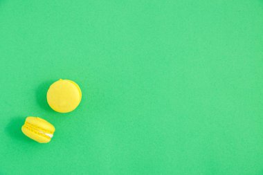 yeşil arka plan üzerinde renkli macarons veya macaroons çerezleri. Sayfanın Üstü 