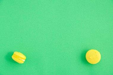 yeşil arka plan üzerinde renkli macarons veya macaroons çerezleri. Sayfanın Üstü 
