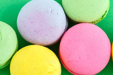 yeşil arka plan üzerinde renkli macarons veya macaroons çerezleri. Sayfanın Üstü 