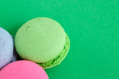 yeşil arka plan üzerinde renkli macarons veya macaroons çerezleri. Sayfanın Üstü 