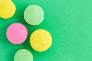 yeşil arka plan üzerinde renkli macarons veya macaroons çerezleri. Sayfanın Üstü 