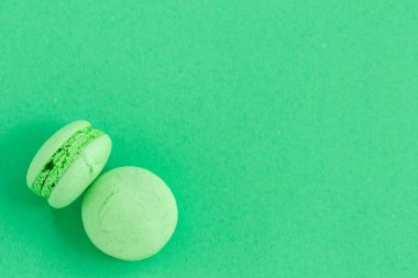 yeşil arka plan üzerinde renkli macarons veya macaroons çerezleri. Sayfanın Üstü 