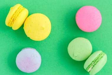 yeşil arka plan üzerinde renkli macarons veya macaroons çerezleri. Sayfanın Üstü 