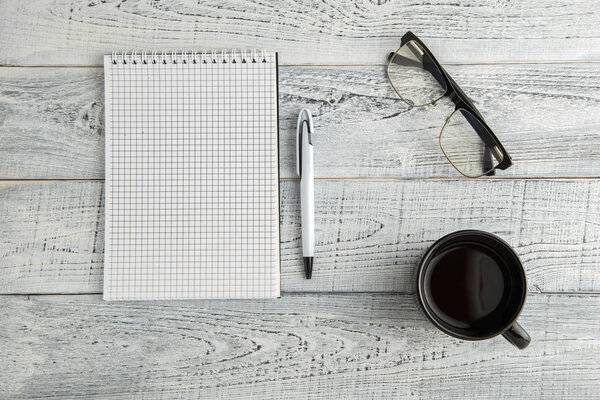 paper notebook,pen and Cup of tea or coffee and optical glasses 